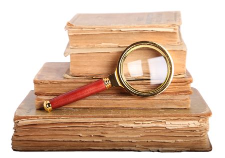 Stack of books and magnifying glass isolated on white backgroundの写真素材