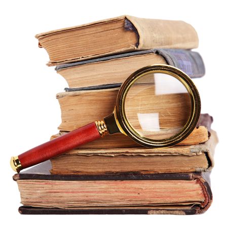 Stack of books and magnifying glass isolated on white backgroundの写真素材