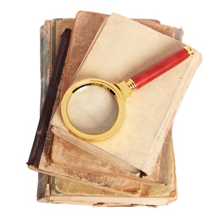 Stack of books and magnifying glass isolated on white backgroundの写真素材