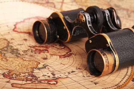 Old binoculars on antique map. Shallow depth of fieldの写真素材