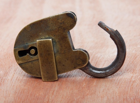 Old brass padlock on wooden backgroundの写真素材