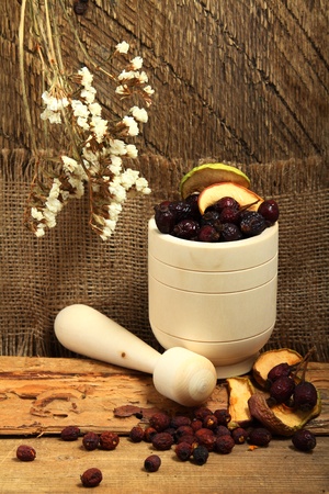 Wooden mortar with dog rose and dried applesの写真素材