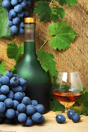 Still life with bottle, glass of cognac and bunch of grapesの写真素材