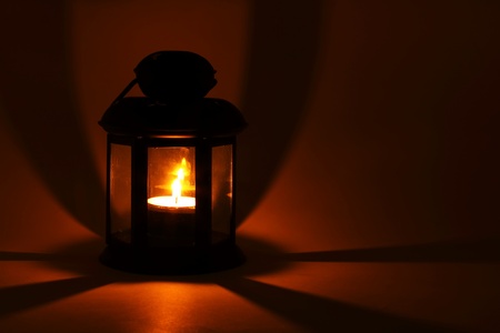 Lantern with burning candle in the darkの写真素材
