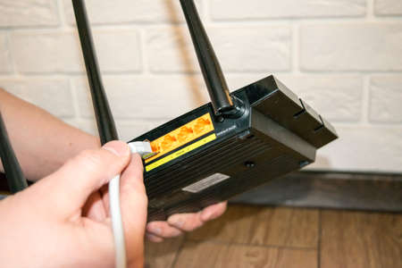WiFi router, back of the router, hand holding the router with wiresの写真素材