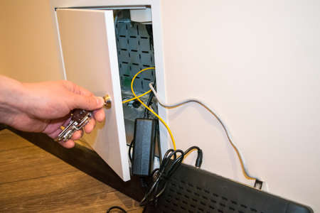 A box for the router, a human hand opens the router's box, next to it lies the router, wiresの写真素材