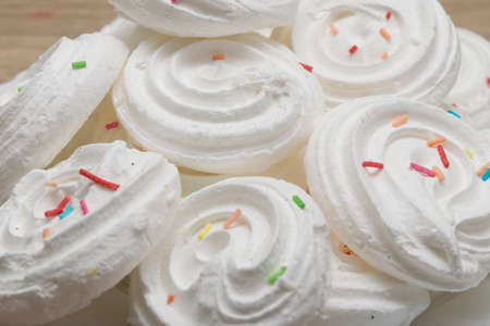 Close-up of white meringues with colored sprinkles