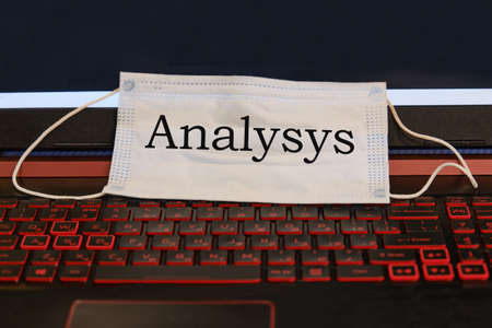 word Analysis written on a medical mask. The mask is on the laptop keyboard.の写真素材