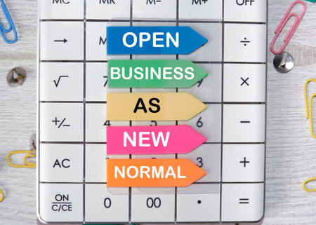 OPEN BUSINESS AS A NEW NORMAL text on paper on a calculator.