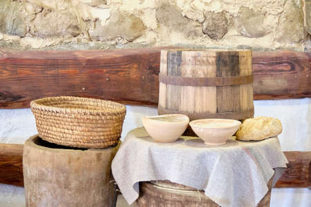 Vintage bowls with flour next to bread on a wooden barrel background