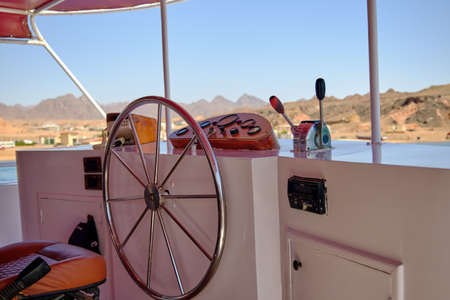 steering wheel on a luxury yacht with a view of the shore. The concept of active recreation.