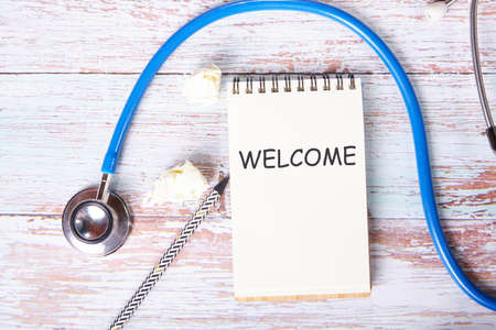 A welcome word written in a notebook near the stethoscope. Medical concept.