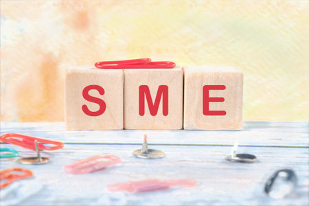 Wooden cubes with text SME (Small and medium-sized enterprises) on a colored background. Financial, marketing and business conceptsの写真素材