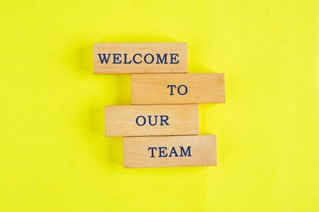 Concept words Welcome to our team on wooden blocks on a lemon background. Business conceptの写真素材