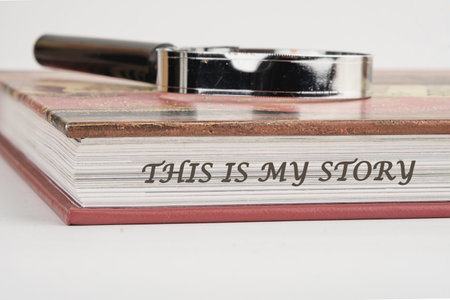 Business and my story concept. Text This is my story on a book with a magnifying glass on top on a...