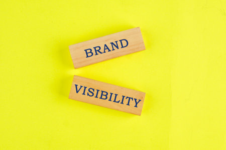 Words Brand visibility on wooden blocks on a lemon background. Business conceptの写真素材