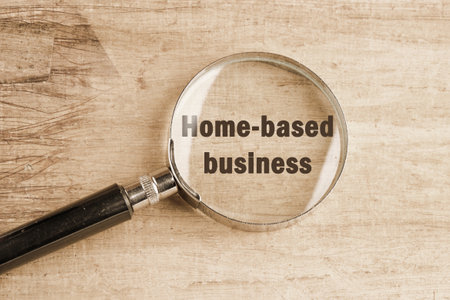 Text Home based business visible through a magnifying glass on an old faded backgroundの写真素材