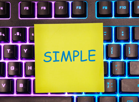 SIMPLE word it is written on a yellow sticker on the illuminated keyboardの写真素材