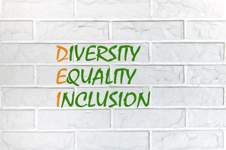 Business concept. Words DEI, diversity, equity, inclusion writing on the wall is made of white decorative bricksの写真素材