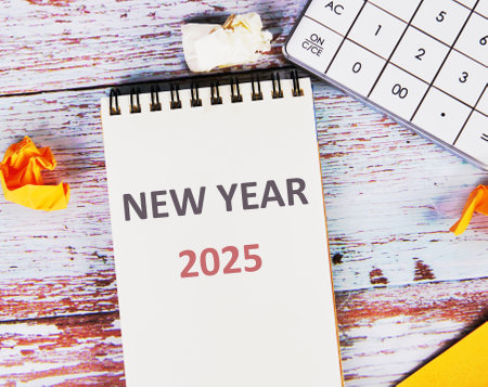 Celebrate NEW YEAR 2025. Text New Year 2025 written in a notebook on a blank page, lying on old...