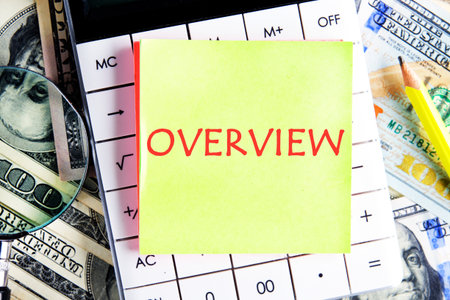 Info concept. OVERVIEW word on a yellow sticker on the calculator against the background of dollar...