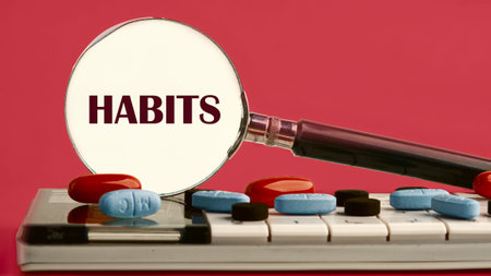Regular tendency or practice Routine concept. HABITS written through a magnifying glass on a...
