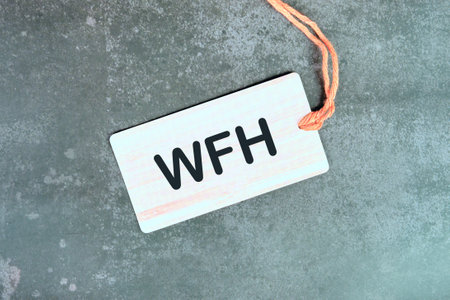 WFH - Work From Home. New business concept. Text WFH written on a light card on a gray background....