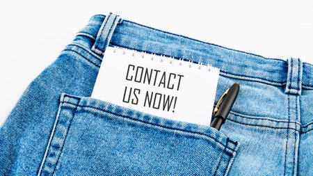 CONTACT US NOW word description on a notebook from a pocket next to a pen