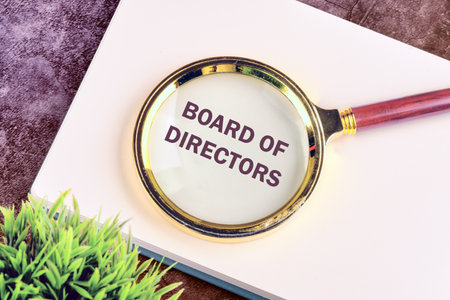 Business concept. Text BOARD OF DIRECTORS through a magnifying glass on a blank sheet of notepad