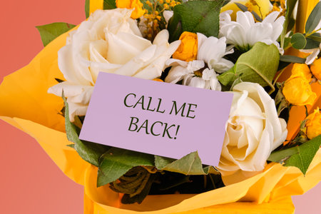 Text CALL ME BACK on a purple business card in a bouquet of delicate roses