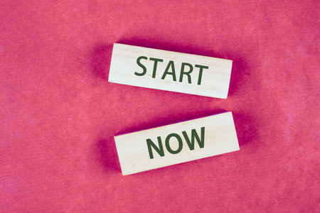 Business and Start now concept. Copy space. Start now symbol on blocks made of wood, top view...