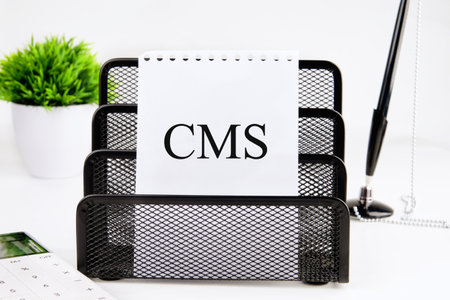 Centers for Medicare and Medicaid Services. CMS written on a blank sheet in a black stand on a white...