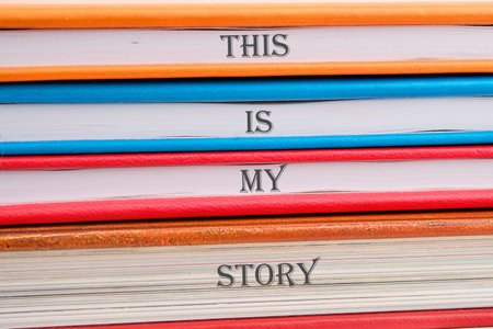 Business and my story concept. Text This is my story on notebooks stacked in a pile