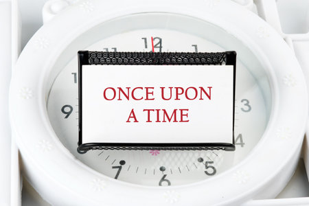 Once upon a time text on a business card on a stand on a lying watch