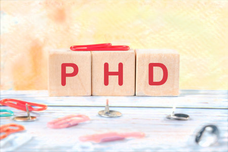 Doctor of Philosophy. Word PhD on wooden cubes on a yellow background