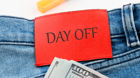 Business and Day off concept. Copy space. DAY OFF symbol on the red leather label of jeans on a...