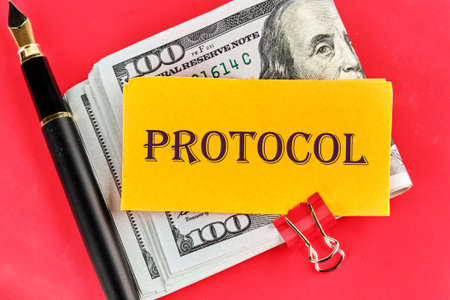 Protocol, text written on a yellow piece of paper on dollars on a red background