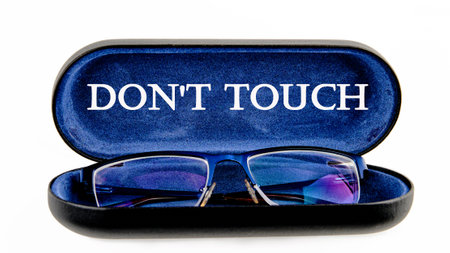 Words DO NOT TOUCH written symbol on the inside of the glasses case on a white background