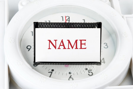 NAME word on a business card on a stand on a lying watch