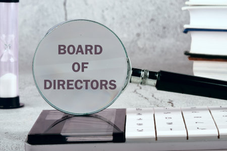 Business concept. Words BOARD OF DIRECTORS through a magnifying glass on a gray background. Black and white imageの写真素材