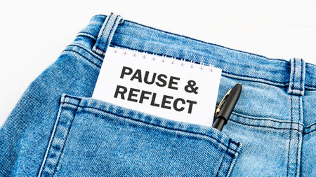 Business and Pause and Reflect concept. Copy space. Pause and Reflect symbol on a notebook on jeans on a white backgroundの写真素材