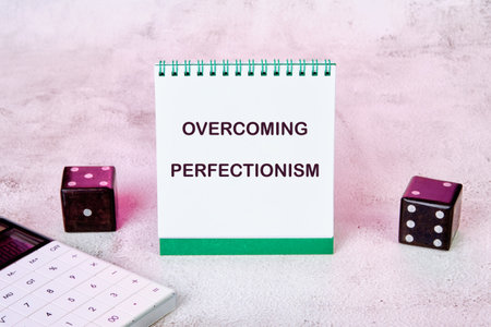 Business Overcoming perfectionism concept. Copy space. Concept words Overcoming perfectionism on a notebook standing verticallyの写真素材