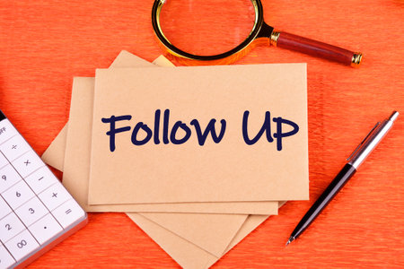 Business concept. Copy space. The words Follow Up on postal envelopes on an orange background, top viewの写真素材