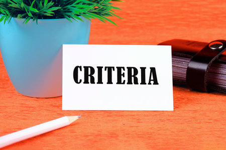 Criteria Controlling Follow Guidelines Conduct Concept. Criteria word on a white business card on an orange backgroundの写真素材