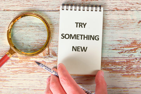 TRY SOMETHING NEW words in a notebook against the background of old boards. A conceptual phraseの写真素材