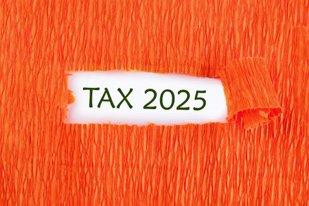 Conceptual tax 2025 symbol. Copy space. Tax 2025 words written conceptual phrase was found on a white background under a torn paperの写真素材