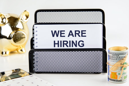 Business and Inclusive Hiring concept. Copy space. WE ARE HIRING written in a notebook in a stand on...