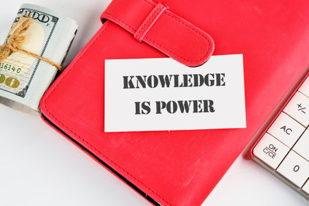 KNOWLEDGE IS POWER words on a business card on a red business book on a white backgroundの写真素材