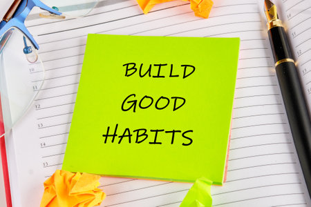 Business, psychological and build good habits concept. BUILD GOOD HABITS on a green sticker on the background of an open notebookの写真素材