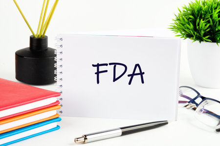 The Food and Drug Administration (FDA) is a federal agency of the Department of Health and Human Services. FDA on a white sheet of an open notebookの写真素材